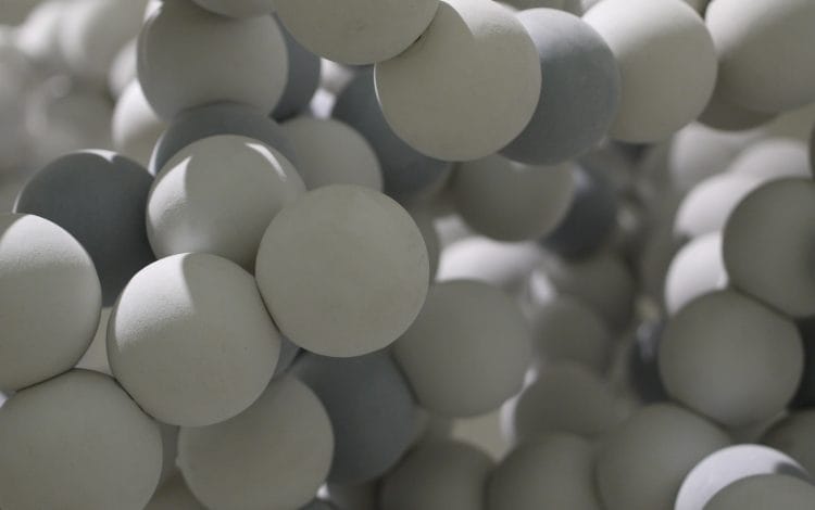 Close-up view of a molecular model consisting of interconnected spherical elements in shades of gray and white.