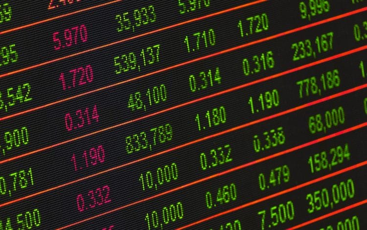 Close-up of a digital screen displaying stock market data with numbers in green and red, representing financial trading and market trends.