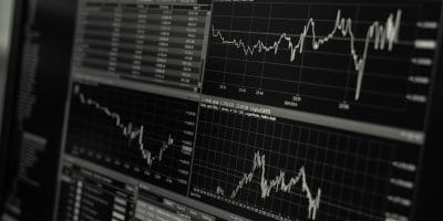 Black and white display of stock market data with multiple charts and graphs showing market trends and statistics.