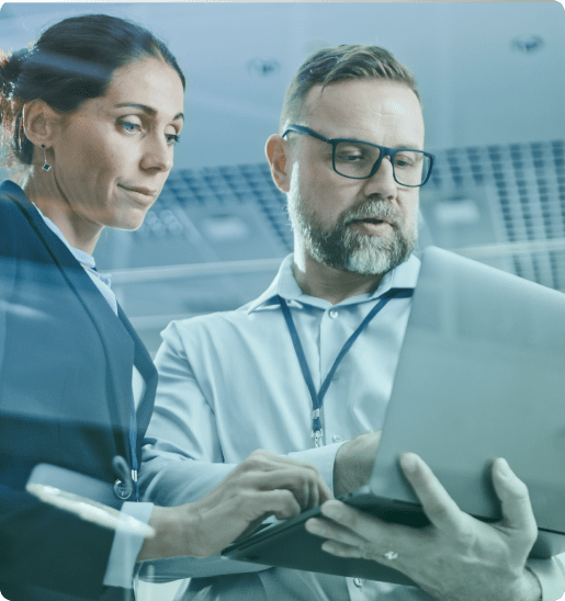 Two life science researchers reviewing data on a laptop in a research facility.