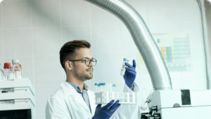 Scientist examining a sample vial in a modern lab environment.